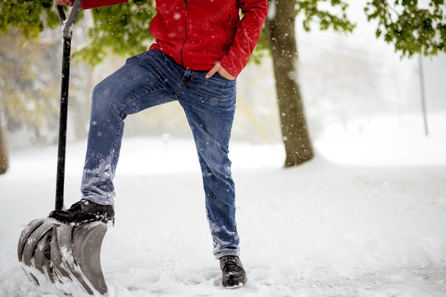 closeup-shot-fo-male-with-his-foot-snow-shovel-while-standing-snowy-field_181624-12187.webp